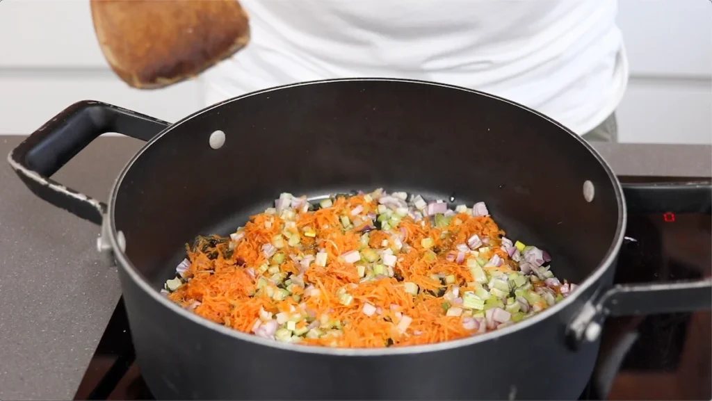 Cocinamos lentamente la cebolla, el apio y la zanahoria en aceite de oliva hasta que estén suaves y aromáticos