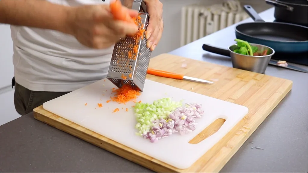 Rallamos la zanahoria para que se cocine más rápido y ayude a espesar la salsa de forma natural