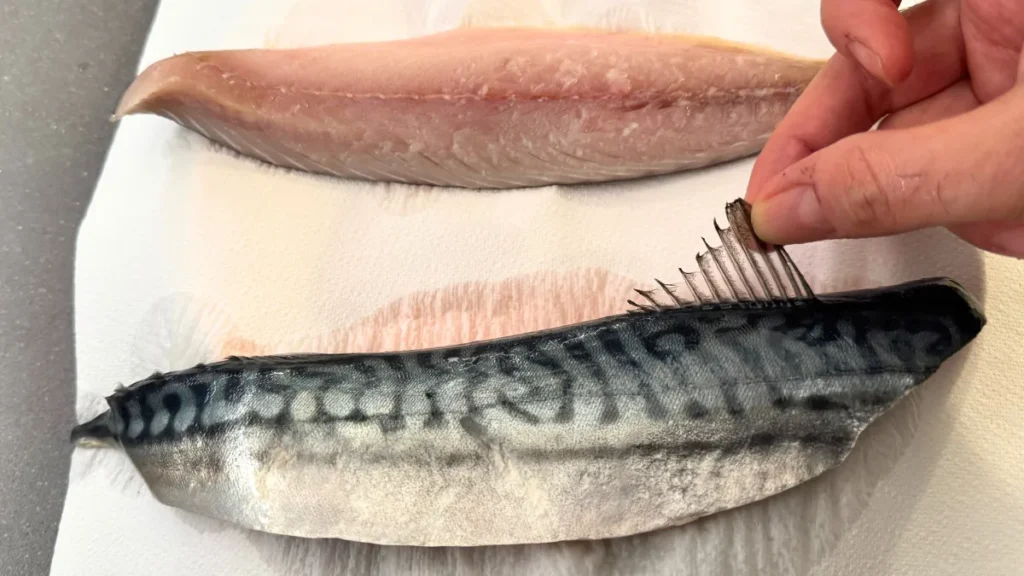 filete de caballa fresco limpiando y retirando la aleta dorsal antes de cocinar