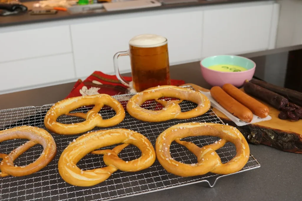 mesa con pretzel caseros cerveza hotdog y salchicha