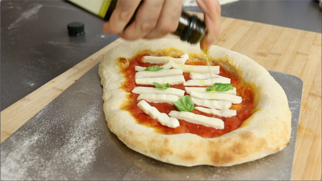 Sacamos la pizza rel horno y añadimos la mozzarella y Parmigiano Reggiano
